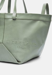 Grüne Leder-Tote-Tasche mit geprägt eingearbeitetem Markennamen "LIEBESKIND BERLIN." Verfügt über strapazierfähige Träger und eine glatte Textur mit minimalistischem Design.