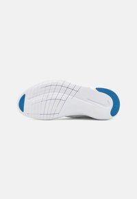 White athletic shoe outsole with a textured surface, featuring a blue accent near the heel and a grid pattern for traction.