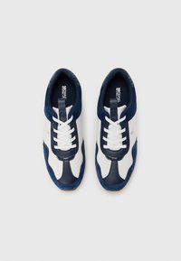 Marineblå og hvite treningssko med overdel i semsket skinn og mesh, rund tå, hvite lisser og logo på tungen og siden. Teksturert detaljer synlig.