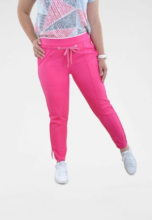 Pantalon de jogging rose vif avec chevilles resserrées, poches avant et cordon de serrage ajustable. Associé à un haut à manches courtes à motif géométrique.
