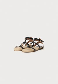 Musta hihnallinen sandaalit, joissa on espadrille-pohja, ja niissä on teksturoidusta juuttikankaan muotoiltu pinta sekä solkiaccentti nilkkahihnassa turvallisen istuvuuden takaamiseksi.