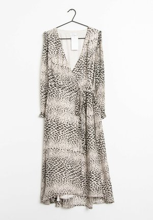 Langärmliges Wickelkleid mit schwarz-weißem abstraktem Leopardenmuster, Bindegürtel, hängt an einem schwarzen Kleiderbügel vor weißem Hintergrund.