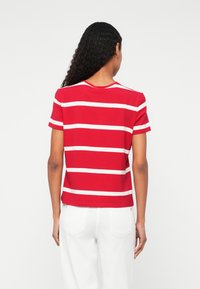 Red and white striped short-sleeve t-shirt, made from soft cotton, featuring a round neckline and a relaxed fit.