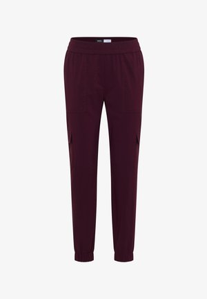 Donker bordeauxrode unisex cargobroek met elastische tailleband en manchetten, voorzien van meerdere zij- en voorzakken voor opbergruimte.
