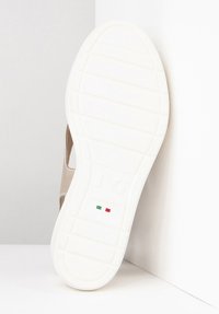 Suola in gomma bianca con grip texturizzato, presenta un upper morbido di colore marrone. Iscrizione "JG" e accenti della bandiera italiana visibili.