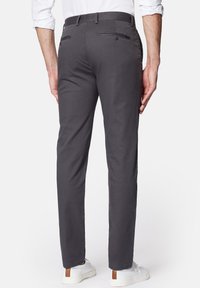 Szare chinosy o gładkiej fakturze, slim fit, z dwiema tylnymi kieszeniami. Stylizowane z białymi trampkami i koszulą na guziki.