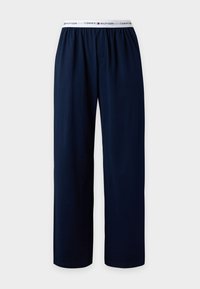 Μπλε σκούρο παντελόνι lounge Tommy Hilfiger με λευκή ελαστική μέση που φέρει το όνομα και το λογότυπο της μάρκας σε κόκκινο, λευκό και μπλε.