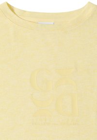 T-shirt jaune clair à col rond avec de grandes lettres stylisées à peine visibles et une phrase inspirante subtilement imprimée sur le devant.