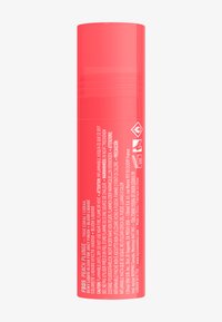 Flytande rouge i en cylindrisk tube med en stark korallfärg. Innehåller varningsetiketter och detaljerad produktinformation tryckt på sidan.