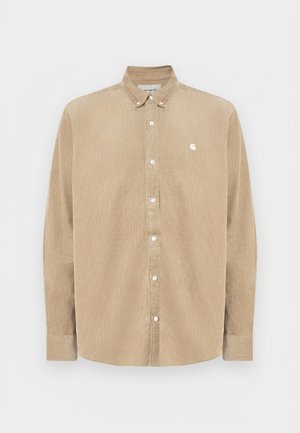 Beige corduroy button-up shirt with a collar, white buttons, and a small logo on the left chest. Features long sleeves and a straight cut.