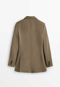 Blazer marrone su misura con una texture liscia, maniche lunghe, rever a punta e due tasche frontali. Spacco singolo sul retro e polsini con bottoni.