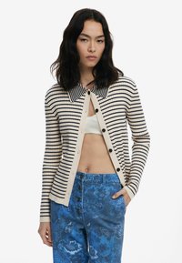 Gestreifter Cardigan mit einem Kragenhals, aus geripptem Stoff in Beige und Marineblau. Verfügt über eine Knopfverschluss und enganliegende lange Ärmel.