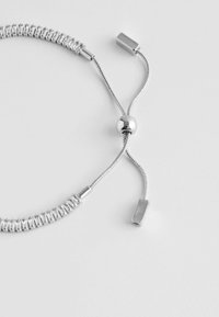 Bracelet en argent avec un design flexible en tresses, comportant des perles cylindriques et des embouts rectangulaires, sécurisé par une fermeture à vis.
