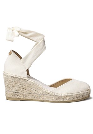 Sandale compensée en toile beige avec une semelle en jute tressé. Présente une bride à la cheville croisée et une conception à orteil arrondi.