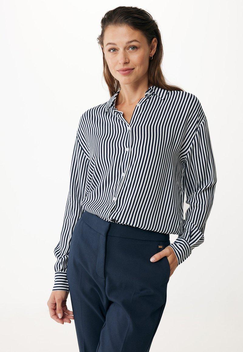 Striped button-up shirt in navy and white, long sleeves, collar, paired with tailored navy trousers. Smooth fabric, relaxed fit, classic design.