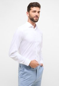 Witte blouse met lange mouwen en een kraag, met knoopsluiting aan de voorkant. Glad stof, slim fit, gecombineerd met lichtblauwe broek.