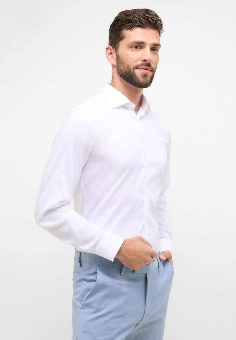 Witte blouse met lange mouwen en een kraag, met knoopsluiting aan de voorkant. Glad stof, slim fit, gecombineerd met lichtblauwe broek.