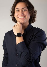 Black metal wristwatch with a round face, featuring a shiny bezel and minimalistic design. Worn on a wrist against a dark shirt.