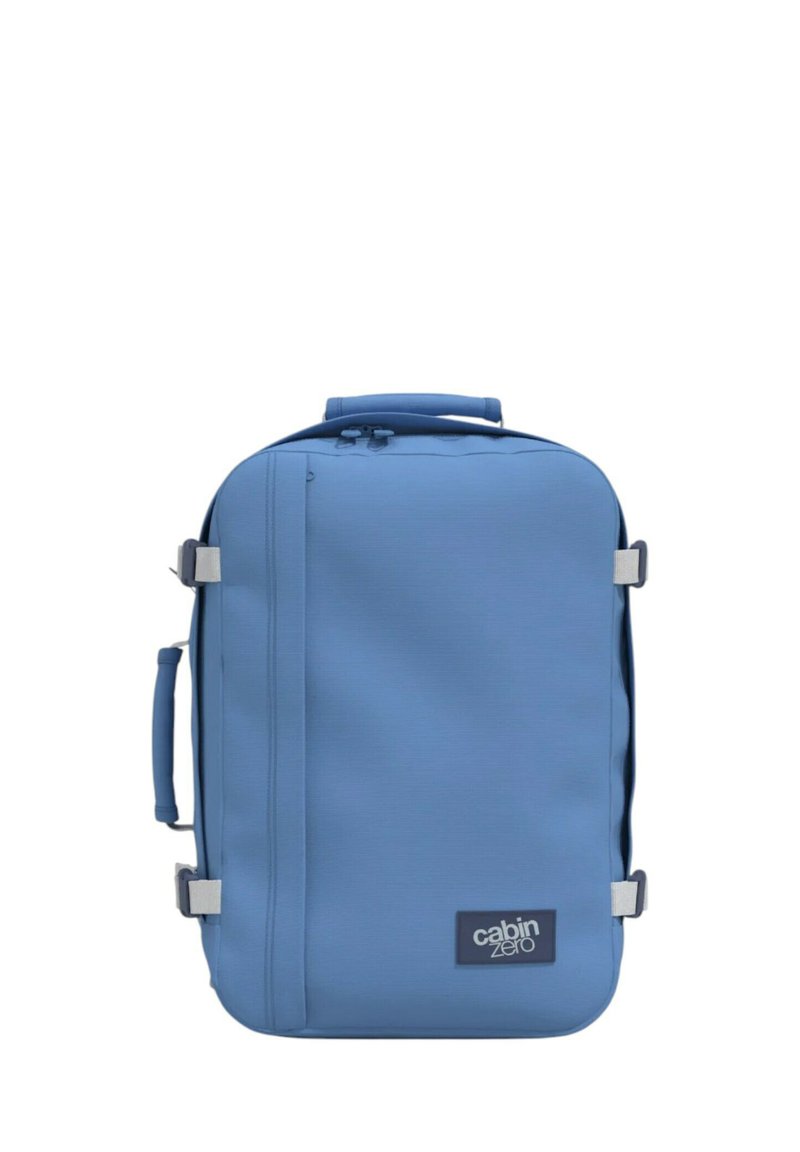 Zaino blu realizzato in un materiale liscio e resistente, forma rettangolare, con maniglia superiore e cinghia laterale, dotato di logo sulla parte anteriore.