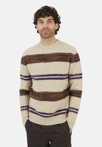 Beige trui met horizontale bruine, blauwe en paarse strepen. Zachte textuur, geribbelde halslijn en zoom, klassieke pasvorm en lange mouwen.