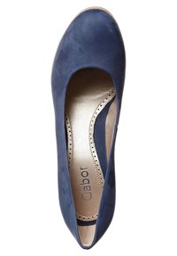 Chaussure plate en daim bleu foncé avec un bout arrondi, présentant un design subtilement découpé, des accents perforés et une semelle intérieure métallique dorée.