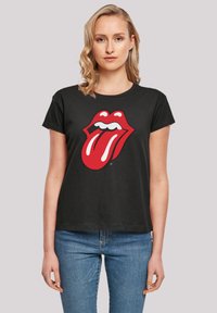 Black short-sleeve t-shirt featuring a large red tongue logo design with white accents. Fabric appears smooth and casual.