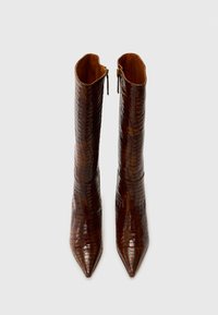 Bottines à bout pointu marron avec un motif crocodile brillant, tige haute et fermeture éclair dorée sur le côté. Doublure intérieure lisse.