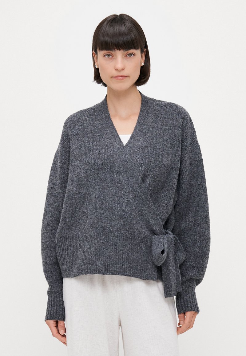 Grau umwickelter Cardiagan aus einem weichen Strickstoff, mit einem Bindegürtel in der Taille, langen Ärmeln und einer entspannten Silhouette.