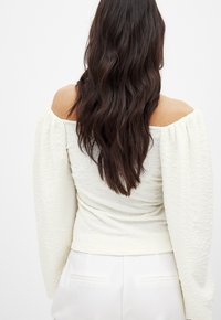 Witte, geweven off-the-shoulder top met pofmouwen, getailleerde bodice en geraffineerde details bij de taille. Glad, lichtgewicht stof.
