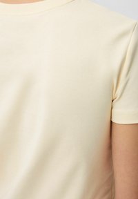 Lichtgeel T-shirt met korte mouwen, gemaakt van een zachte katoenmix, met een klassieke ronde hals en een gladde textuur, gezien vanuit de achterkant.