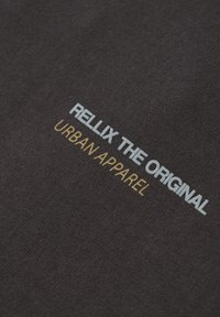 Mørkegrå t-shirt med "RELLIX THE ORIGINAL" i lyseblå og "URBAN APPAREL" i guld, med en tekstureret stofoverflade.