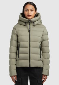 Olijfgroene pufferjack met hoge kraag, voorrits, twee zijzakken en ribgebreide manchetten. Heeft een matte afwerking en horizontale stiksels.