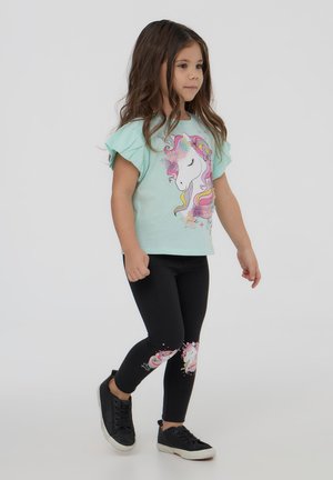 Camicia verde chiaro a maniche corte con bordi arricciati, con stampa di un unicorno, abbinata a leggings neri con design di unicorni coordinati.