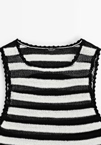 Haut en maille sans manches à rayures horizontales noires et blanches, avec bords festonnés et col rond, étiqueté Massimo Dutti.