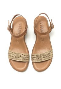 Sandalias de cuero marrón que presentan una correa de yute trenzado con acentos dorados, suela plana y correas ajustables en los tobillos. Plantilla texturizada.