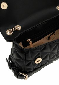 Sac à main en cuir matelassé noir avec un accent en métal doré, doté d'un détail en chaîne et d'une poche intérieure zippée.