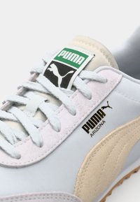 Svijetloplave Puma Arizona tenisice imaju meke suede akcentne dijelove, zaobljen vrh, bijele vezice i oznaku na jeziku s brendom, te teksturiranu potplat.
