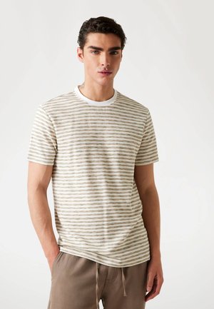 Striped t-shirt featuring a round neckline, light beige base with green and brown stripes, and short sleeves, made from a soft fabric.