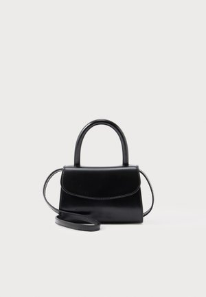 Mała czarna skórzana torebka z zaokrąglonym uchwytem i odpinanym paskiem na ramię na białym tle.