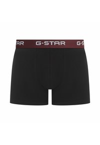 Czarne bokserki G-STAR z bordową elastyczną taśmą w pasie, na której znajduje się białe logo marki. Materiał wydaje się gładki i elastyczny, stworzony z myślą o komforcie.