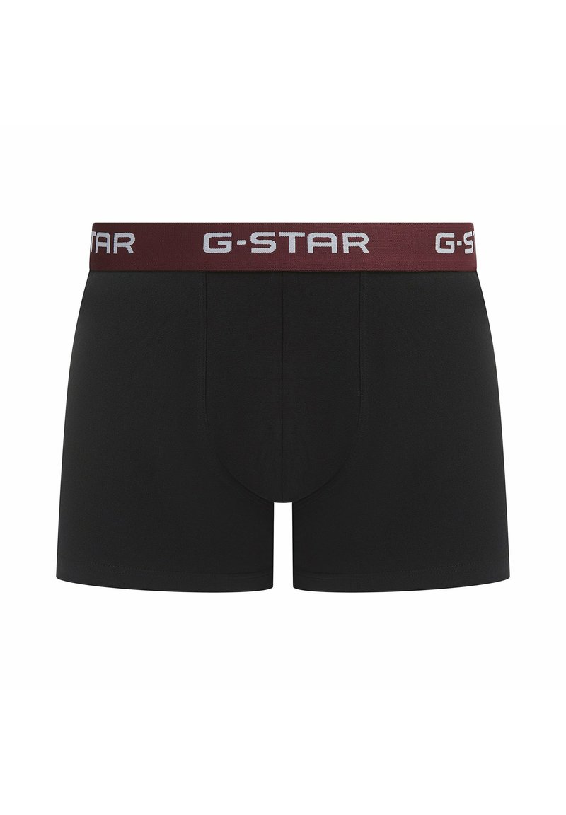 Boxers G-STAR noirs avec une ceinture élastique bordeaux ornée de lettres blanches. Le tissu semble lisse et extensible, conçu pour le confort.