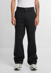 Black wide-leg trousers made of cotton blend fabric. Features a front button closure, belt loops, and a relaxed fit.