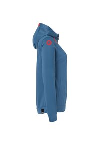 Veste softshell bleue avec capuche, dotée d'accents rouges, d'une poche zippée sur le côté et d'un logo sur l'épaule. Texture lisse.