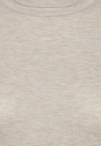Gros plan sur un tissu côtelé beige présentant une fine texture tricotée avec un col rond en haut.