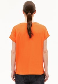 Oranges T-Shirt mit kurzen Ärmeln, lockerer Passform, rundem Halsausschnitt und umgeschlagenen Ärmeln. Weicher Stoff mit glatter Textur, schlichtes Design.