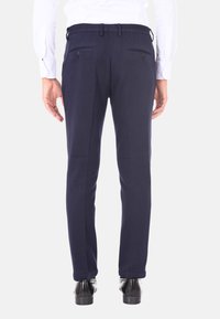 Pantaloni tailored blu navy realizzati in tessuto liscio, con una silhouette aderente, tasche posteriori piatte e cintura con passanti.
