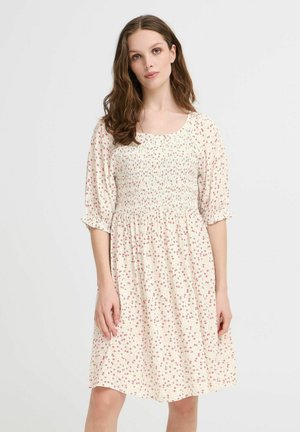 Floral dress with a smocked bodice, short puff sleeves, and a flared skirt. Features a cream background and small pink floral patterns.
