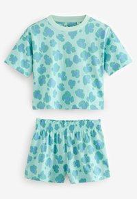 Completo leggero di colore verde menta composto da una maglietta a maniche corte e pantaloni corti. Entrambi presentano un motivo astratto blu e viola.