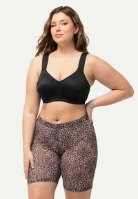 Zwarte gepolsterde beha met brede banden, gecombineerd met biker shorts met luipaardprint en een elastische tailleband en een gladde textuur.