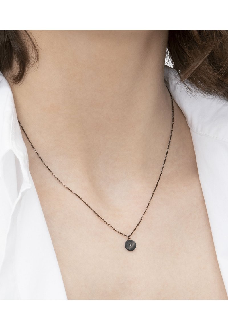 Sort metalhalskæde med en tynd kæde og en lille, cirkulær vedhæng med en struktureret overflade og en lille, farvet sten.